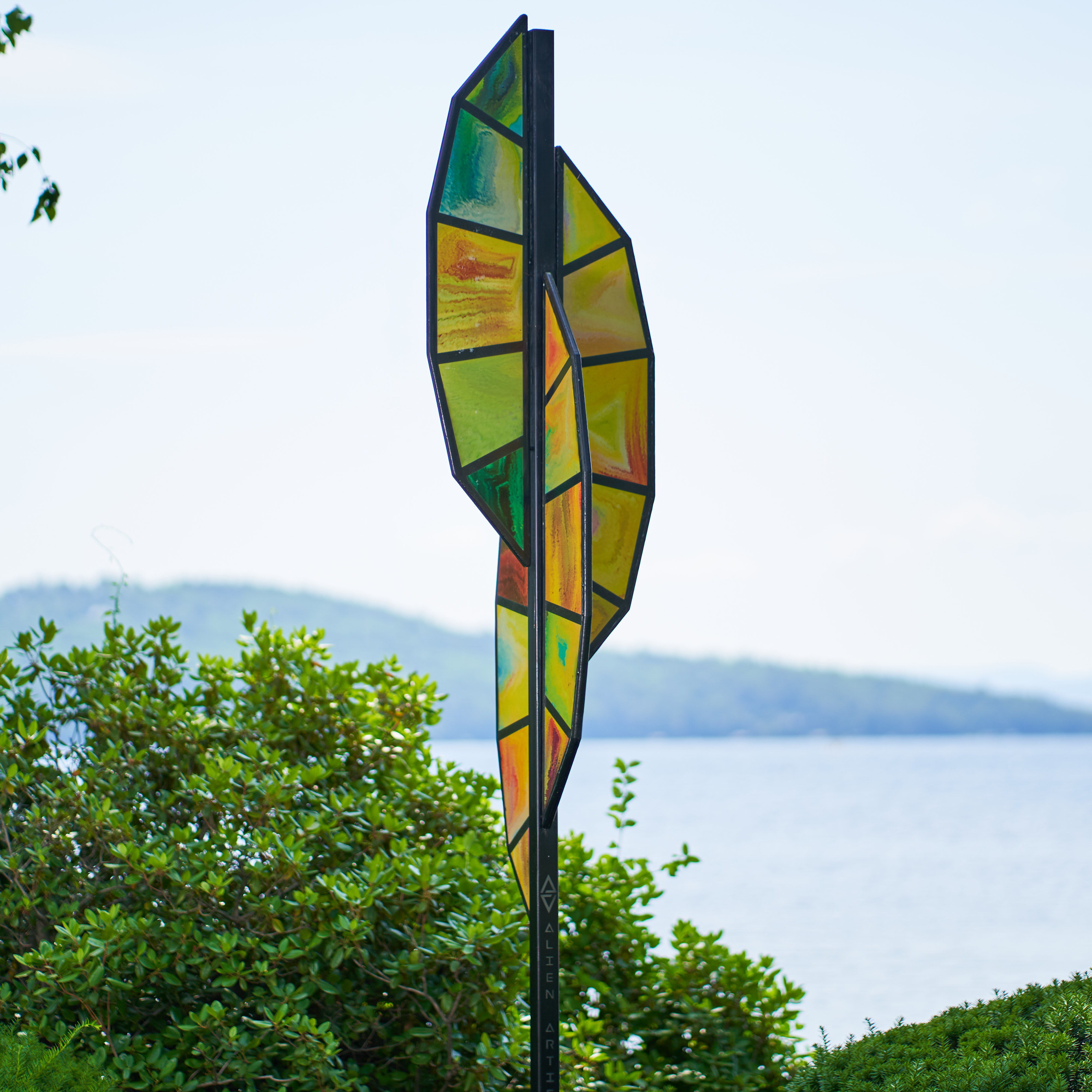 Abstract sculpture positioned in front of a lake. The Mount Washington boat is visible in the water.