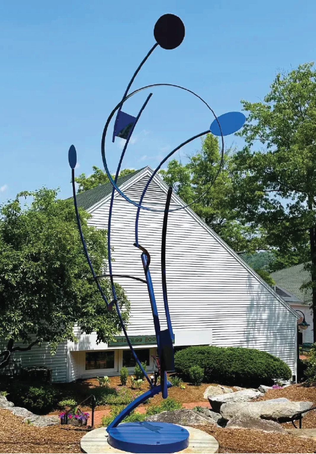 Abstract sculpture positioned in front of a lake. The Mount Washington boat is visible in the water.